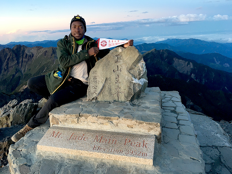 傑誠(Barnaba Buhombe)於玉山3952公尺處展示長榮紀念旗