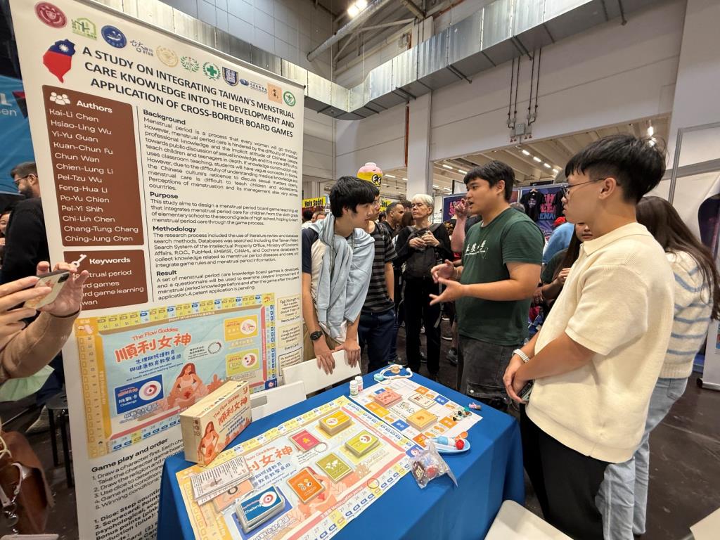 護理系學生黎豐華向詢問的國際友人熱情介紹「順利女神生理期照護」桌遊之設計