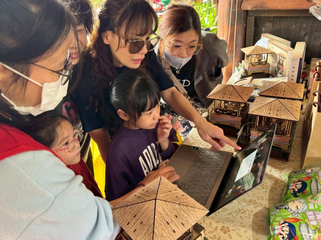 遊客於攤位前遊玩USR計畫所開發茶山虛擬故事館中的小遊戲